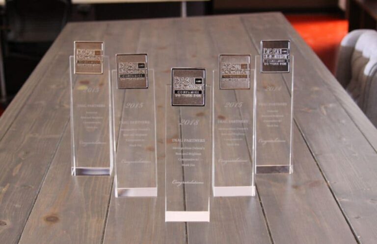 Conference table full of Diag National best and brightest companies to work for trophies